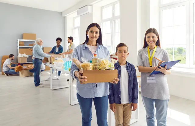 Volunteers welcoming a family in a community centre